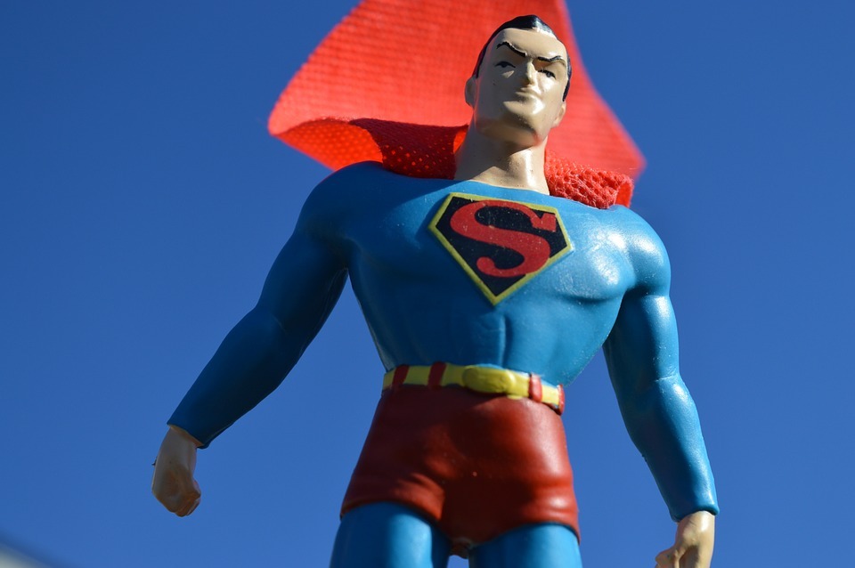 superman toy, red cape, blue background